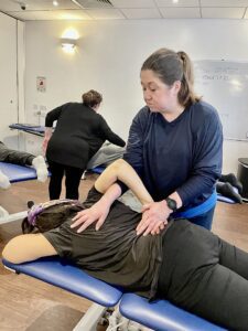 Massage therapist performing assisted spinal twist